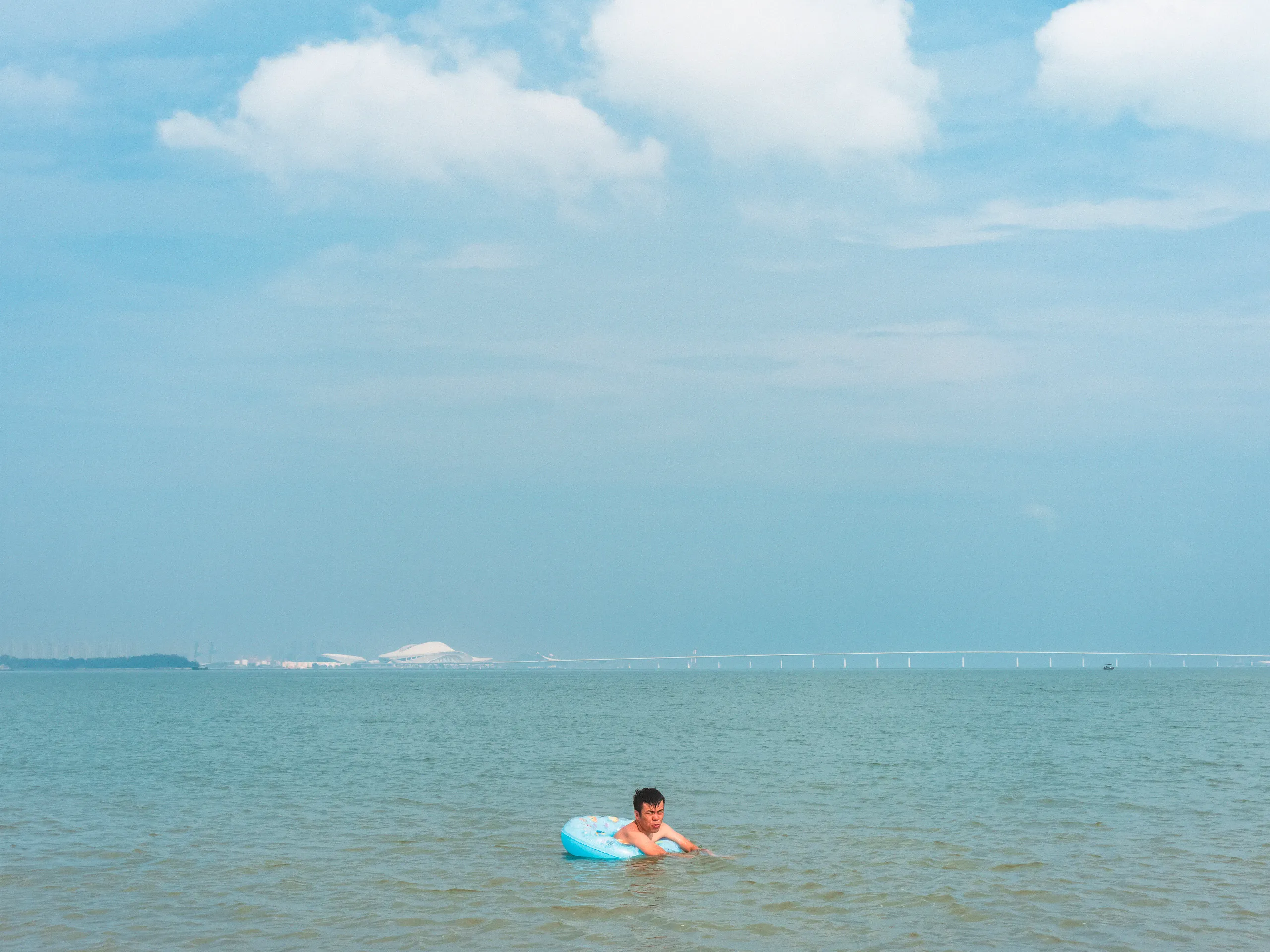 The Strip: Staying Afloat — swimming in the sea off Xiamen beach, photograph by Andras Ikladi