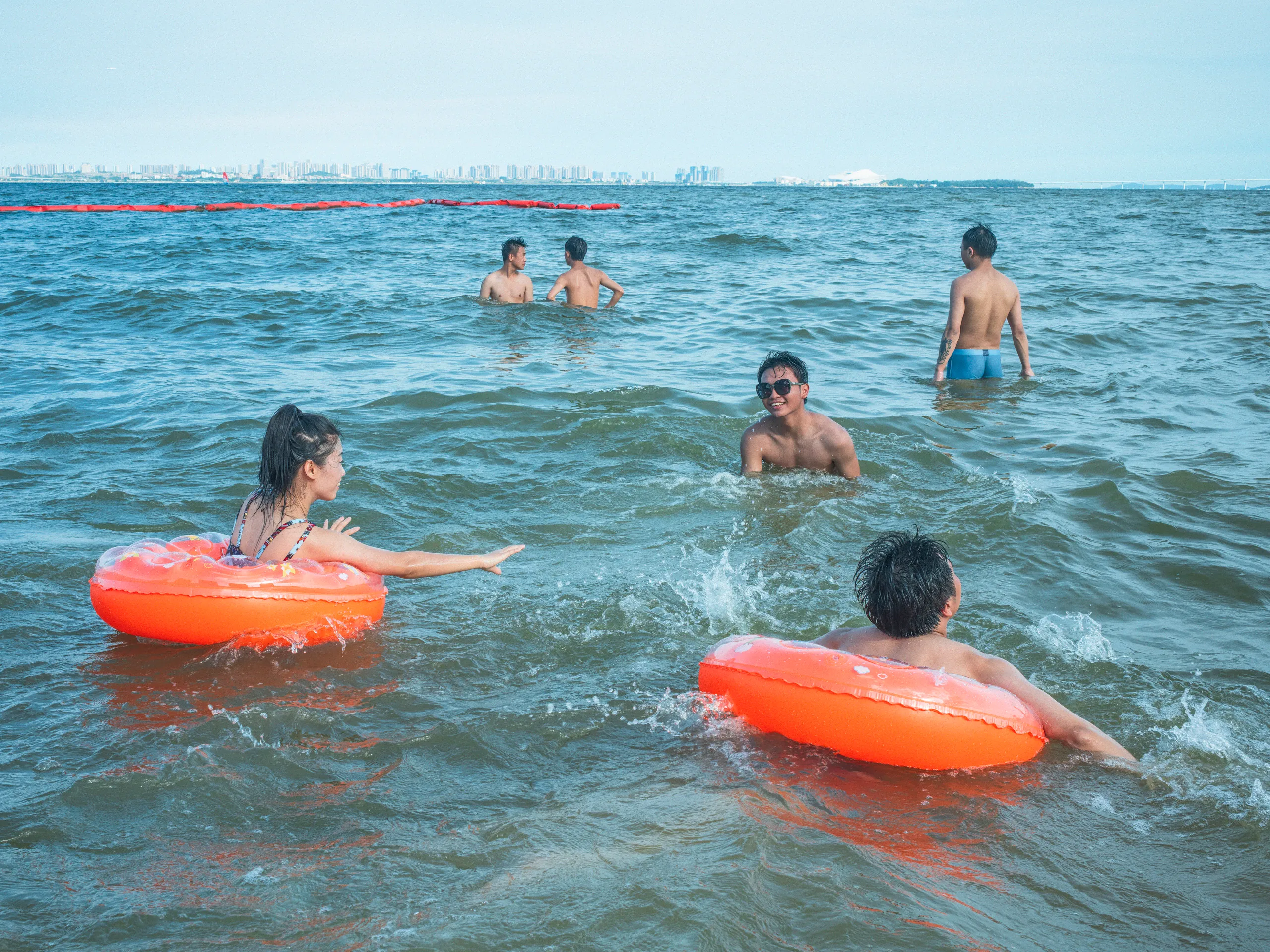 The Strip: Staying Afloat — swimming in the sea off Xiamen beach, photograph by Andras Ikladi